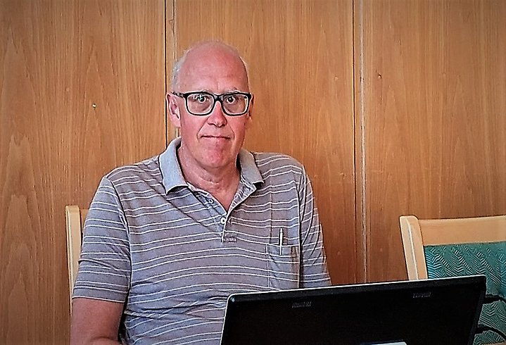 En man sitter bakom en dator i Sessionsalen på Gnosjö kommunhus.