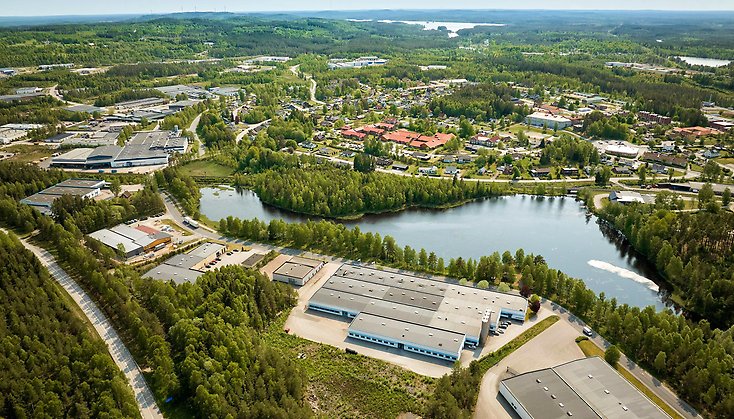 Industrier ovanifrån inbäddade ibland granskog.