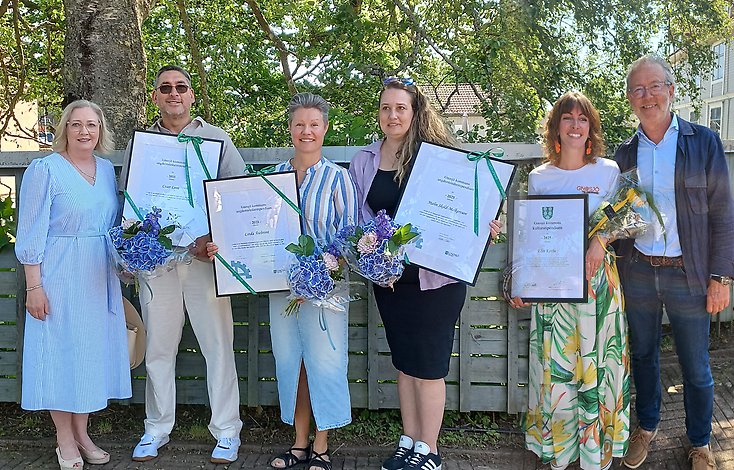 Stipendiater uppställda med blommor och diplom.