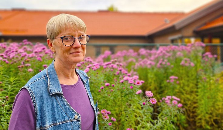 En kvinna står framför höstastrar utanför Rosendals äldreboende.