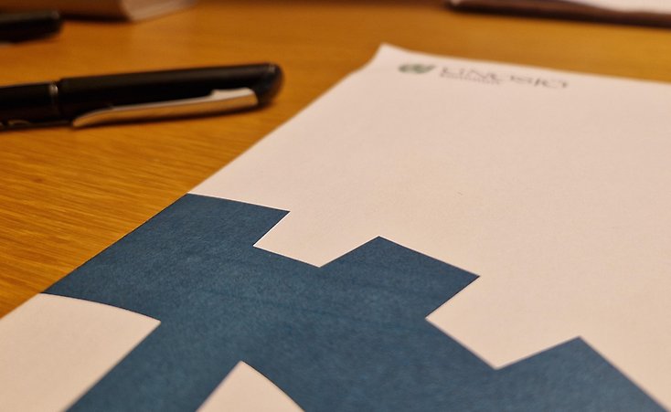 Ett kuvert och en penna på ett bord.