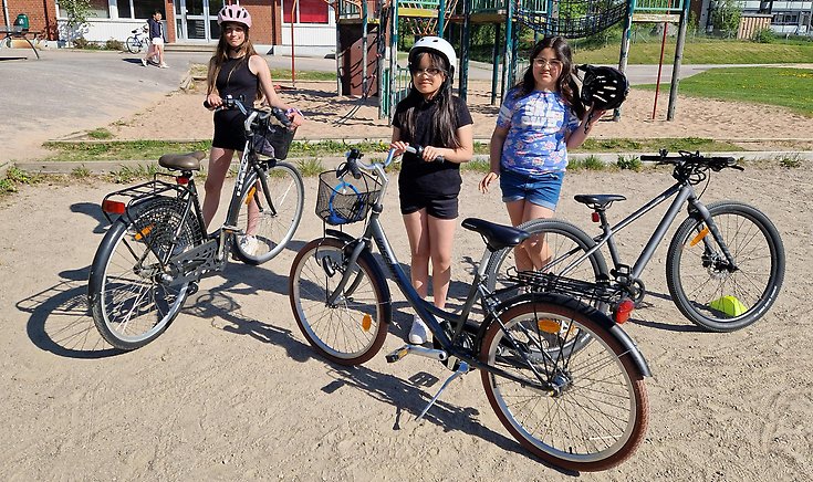 Fyra tjejer med cyklar utanför Bäckaskolans mellanstadium.
