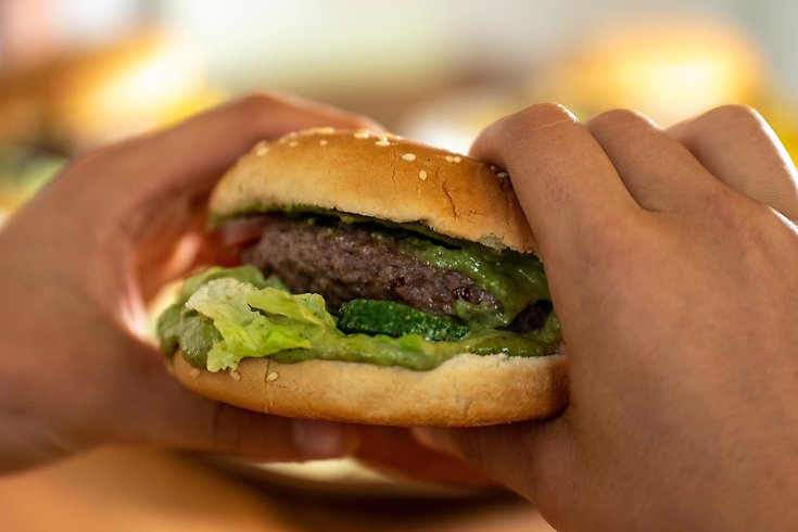 Hamburgare som någon håller i sina händer.