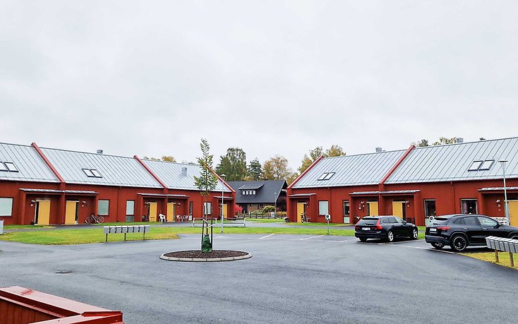 Radhuslänga med parkering framför.