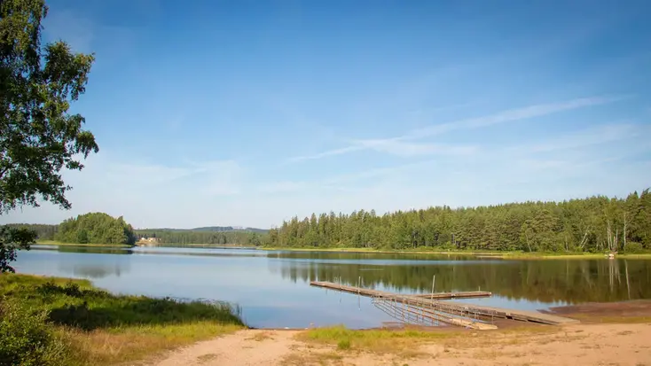 Skogssjö och en liten strand.