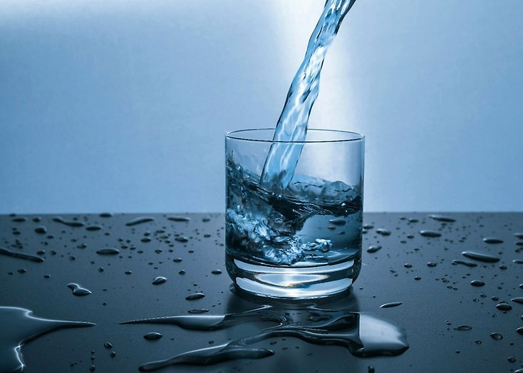 Ett vattenglas där det rinner vatten ner i glaset.